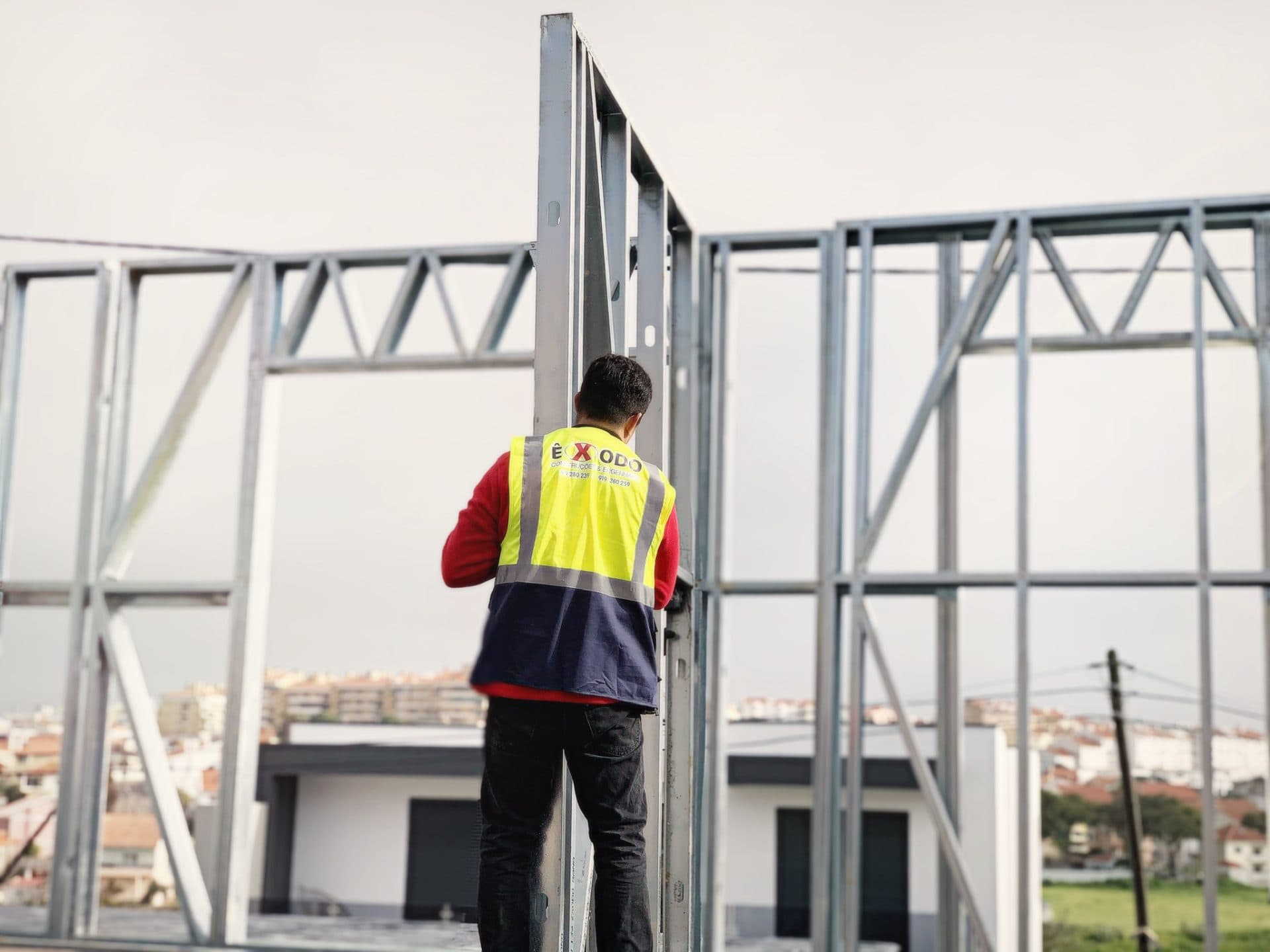 Trabalhador com parafusadora vermelha a montar perfil LSF